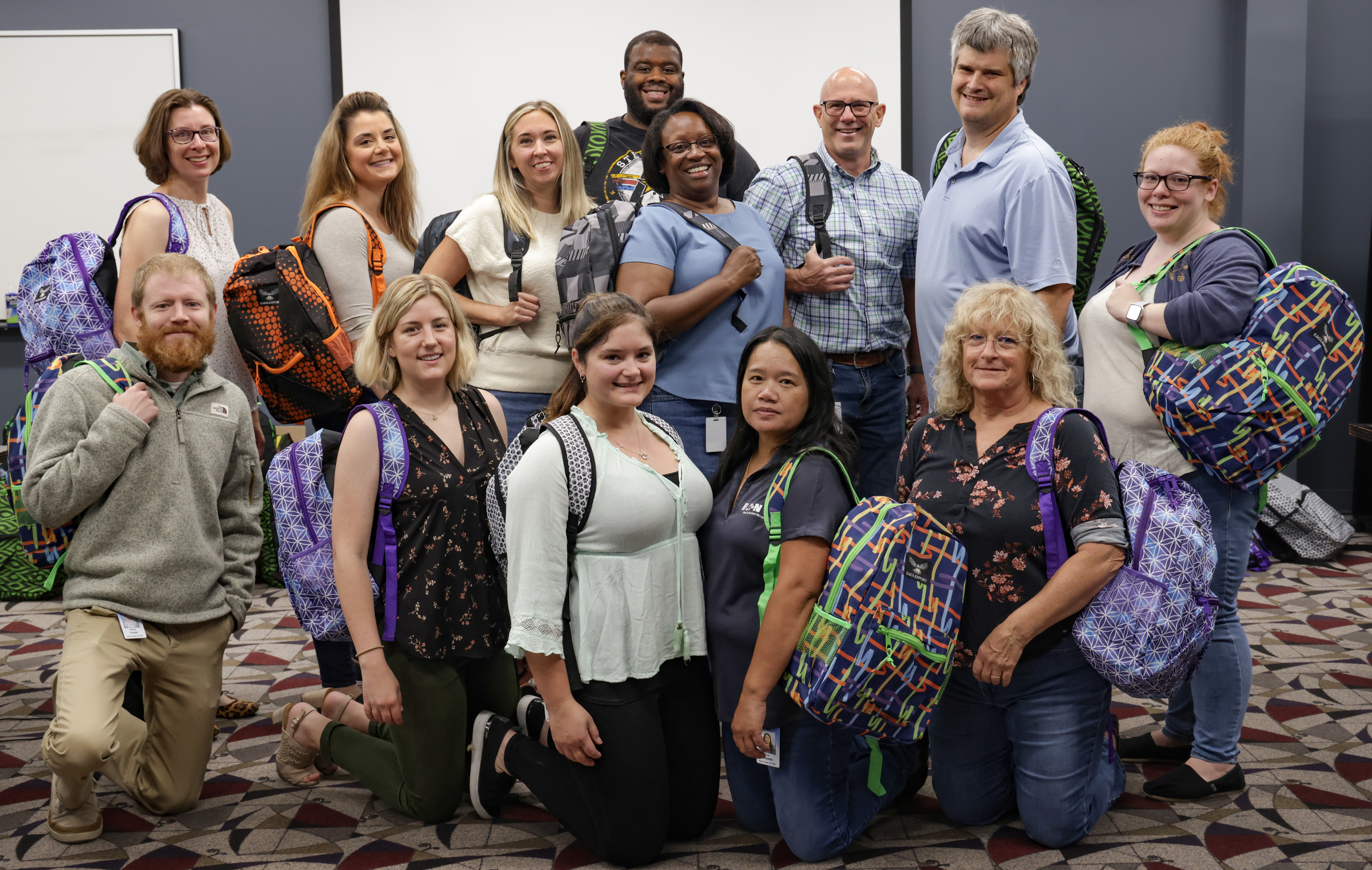 Eaton employees pose with the backpacks they have packed for the Annual School Supply drive