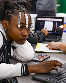 A student works on math homework at the Reynolds Middle School Community Night with her family and a volunteer tutor. 