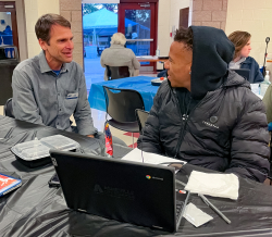 CEO of United Way, Dan Leroy, sits with a student at Asheville High School during the first Community Night of the 2022-23 school year. 