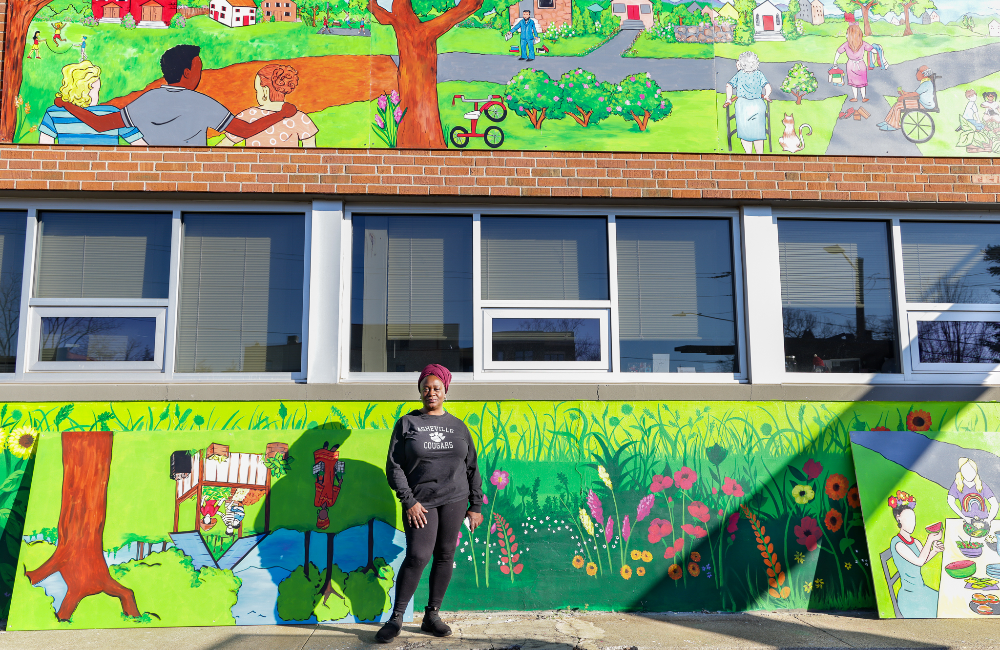 Artist Jenny Pickens beside her 16-panel mural. 