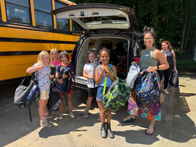 Students receiving backpacks at a distribution event