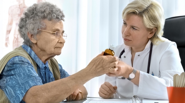 elderly woman getting medication from doctor